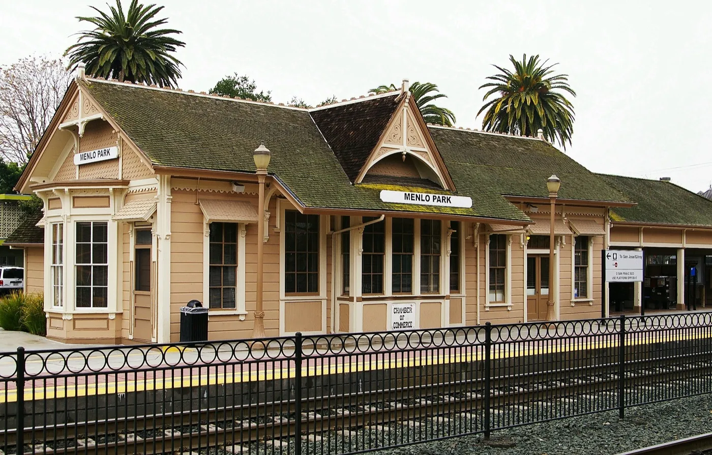 The historic Menlo Park train station, a low Victorian-era wooden depot with a peaked shingled roof.