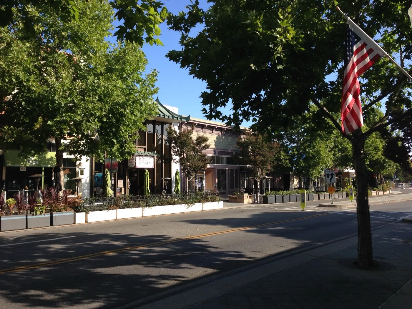 Downtown Castro Street in Mountain View, California, lined with shops and restaurants under a blue sky.